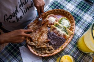 Delicious traditional Mexican dish with meats and colorful sauces served on a decorative plate.